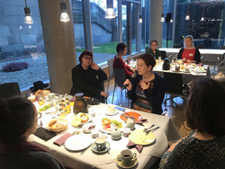 Frau mit Mikro spricht beim Parlamentarischen frühstück, FHK-Geschäftsführerin Heike Herold hört interessiert zu
